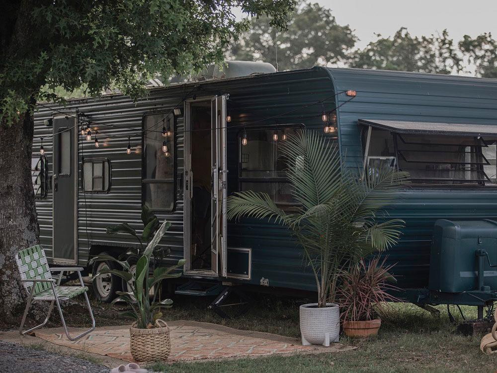 Travel trailers at a site with plants at THE OUACHITA RV PARK