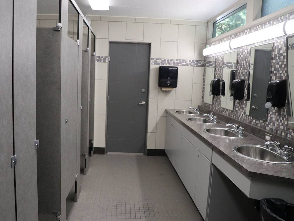 Bathroom with tiled floor and walls and stalls at GORDON HOWE CAMPGROUND