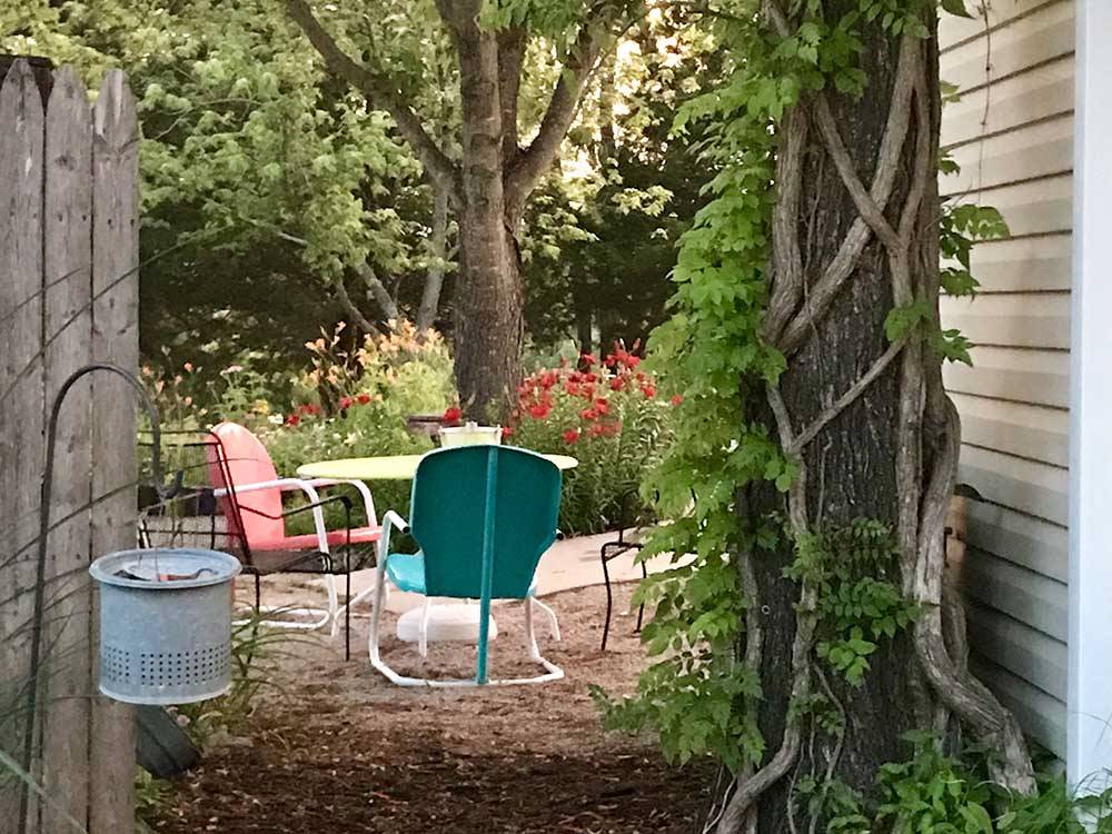 Outdoor chairs near trees and flowers at LAZY DAY CAMPGROUND