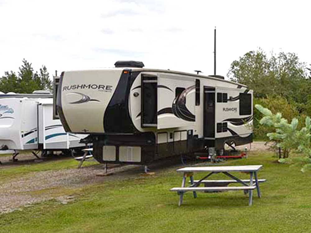 A fifth wheel trailer in a gravel site at NORTHERN LIGHTS RV PARK