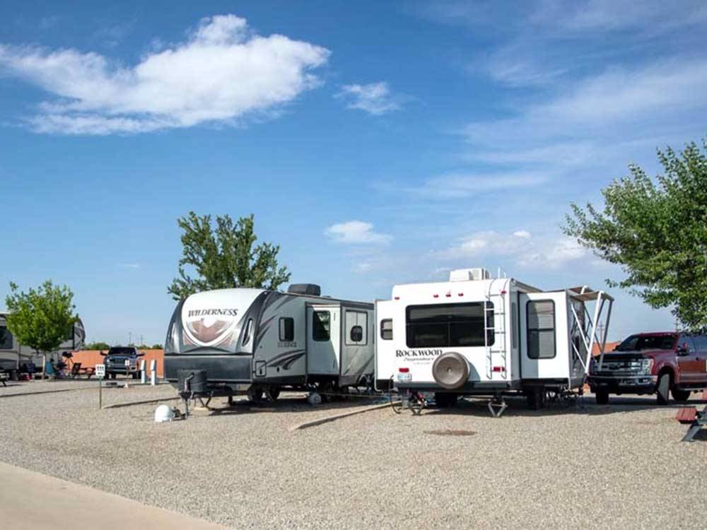 A pair of trailers in adjoining campsites at TOWN & COUNTRY RV PARK