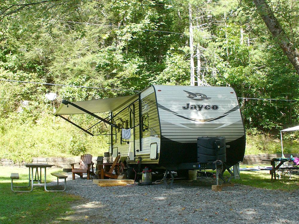 Trailer in a gravel site at WHISPERING PINES CAMPGROUND & RV PARK