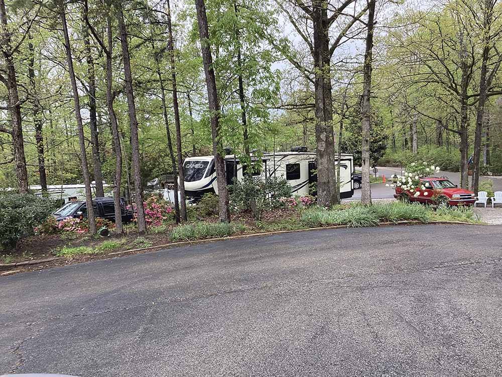 A motorhome in an RV site under trees at CAMPGROUND AT BARNES CROSSING