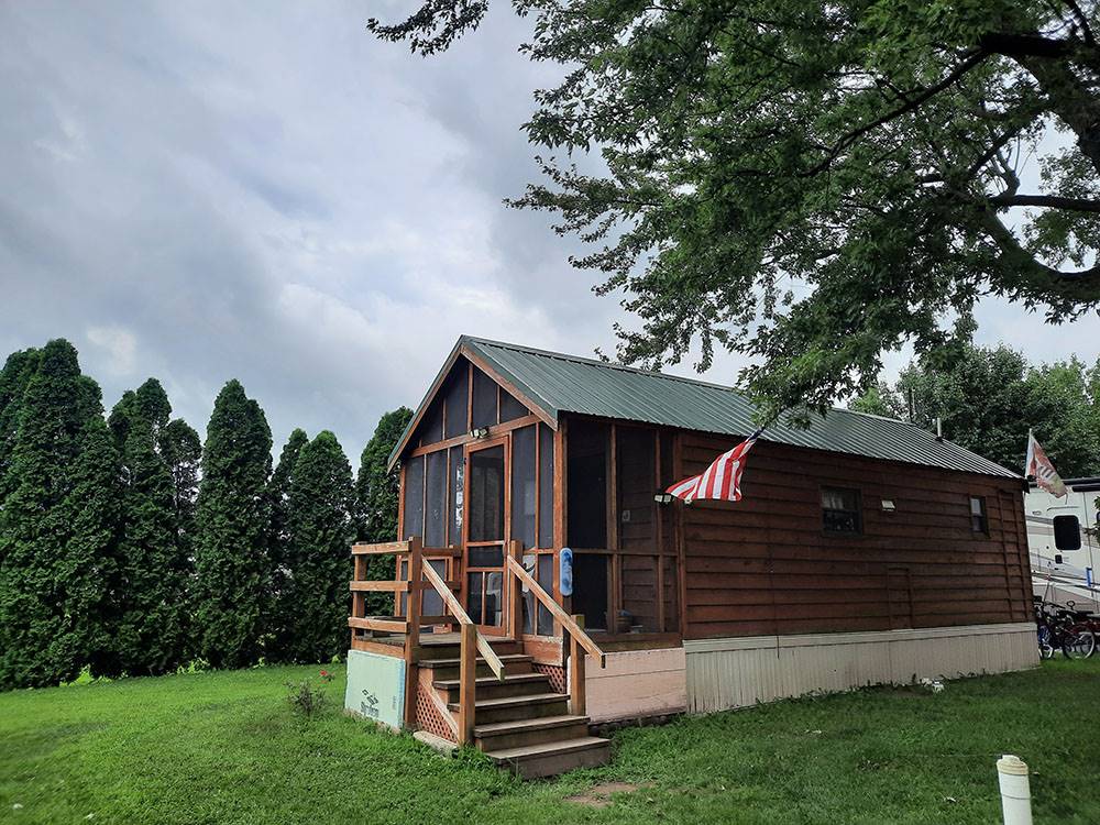 A wooden cabin with a deck at SHIPSHEWANA CAMPGROUND SOUTH PARK