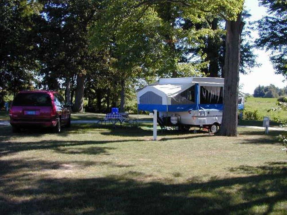 Pop up tent and car under the trees at SHIPSHEWANA CAMPGROUND SOUTH PARK