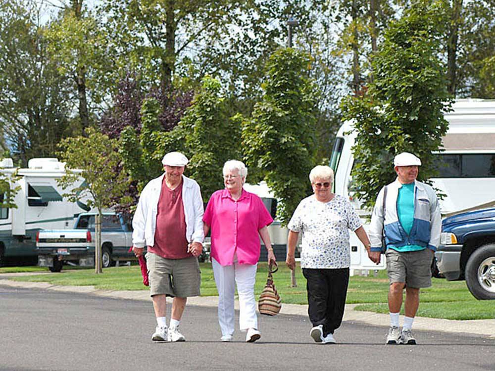 Two couples walking by the sites at OLDE STONE RV RESORT