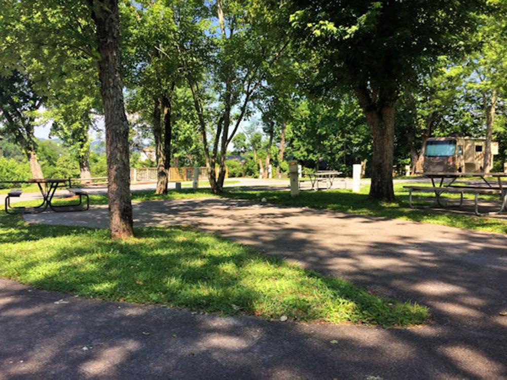 Paved site shaded by trees at FOOTHILLS RV PARK & CABINS
