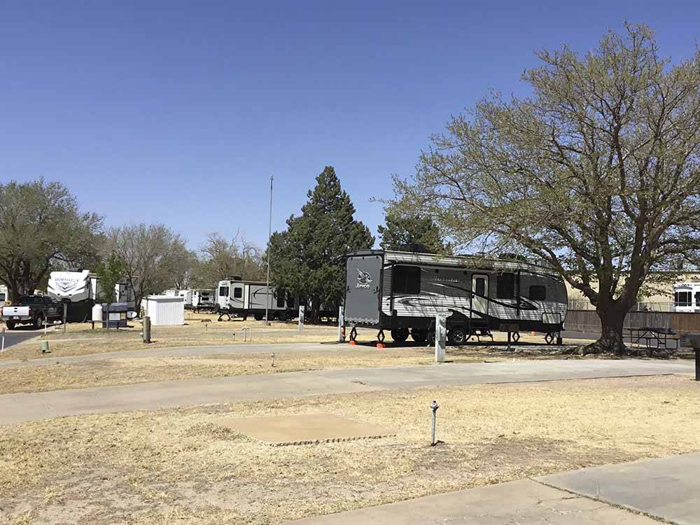 A bunch of RV sites with trees at CAMELOT VILLAGE RV PARK