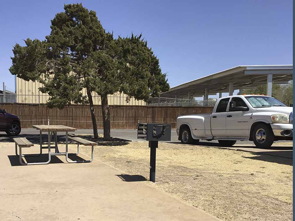 An RV site with a picnic bench at CAMELOT VILLAGE RV PARK