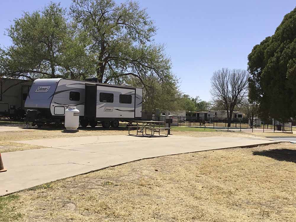 A paved RV site with a picnic bench at CAMELOT VILLAGE RV PARK