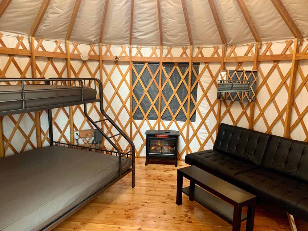 A bunk bed and sofa inside the yurt at TILLAMOOK BAY CITY RV PARK