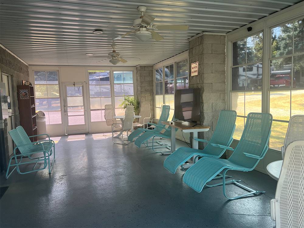 Teal lounge chairs in a sun room at Shipshewana Campground North Park & Amish Log Cabin Lodging