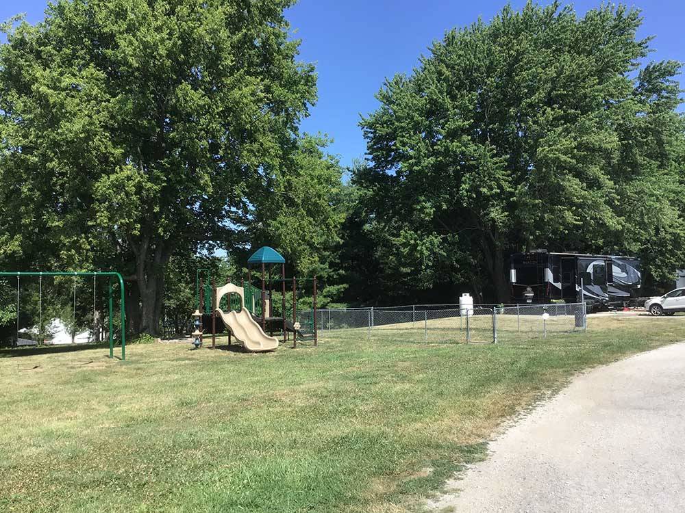 Play structure with slide and swing set on lawn at OWL CREEK MARKET + RV PARK