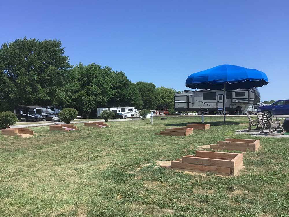 Horseshoe pits on grass in foreground near RVs at OWL CREEK MARKET + RV PARK