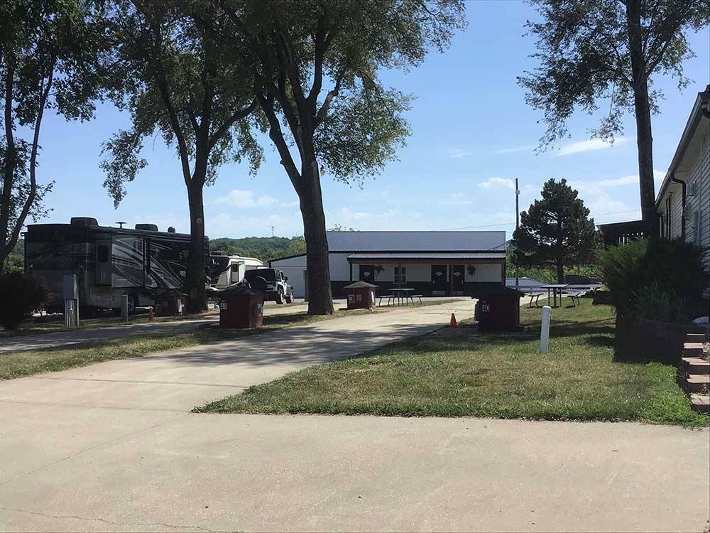 Paved RV sites with picnic tables and shade at OWL CREEK MARKET + RV PARK