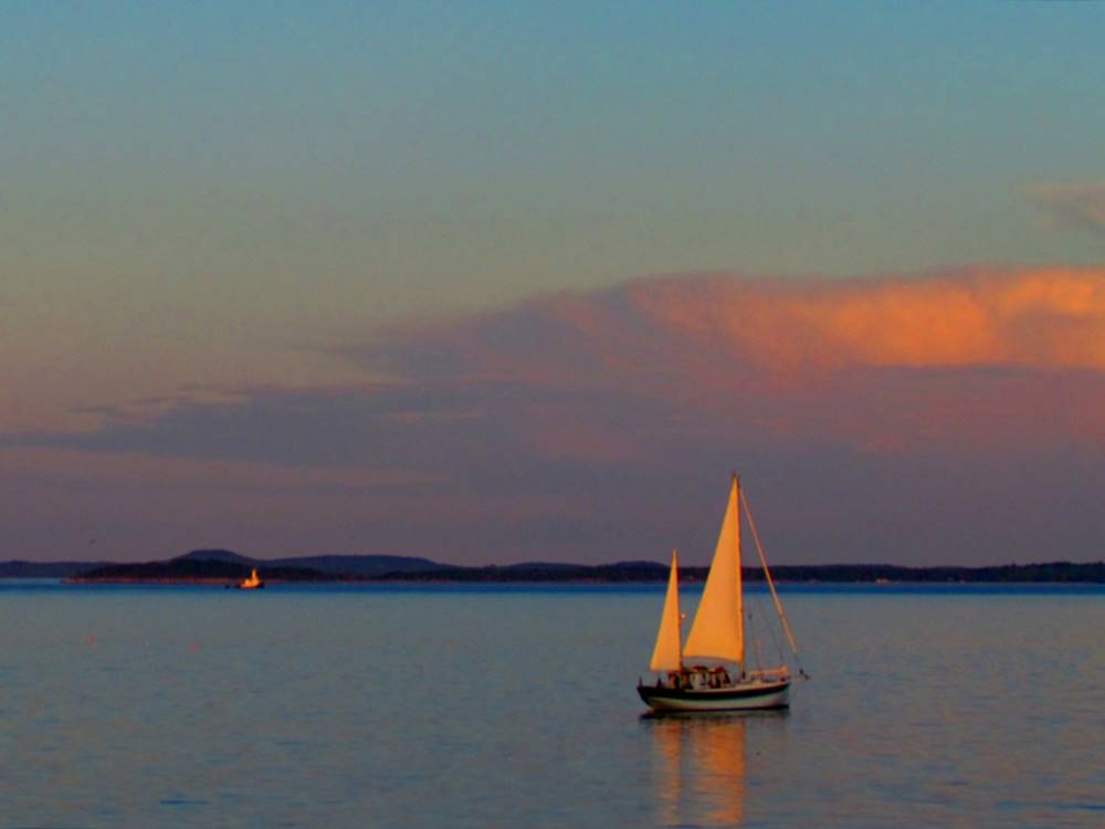 A sailboat on the ocean at sunset