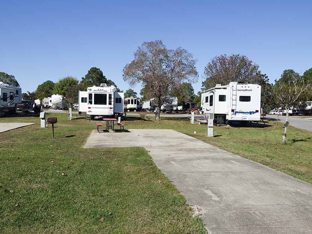 A row of trailers parked in RV sites at GULF BREEZE RV RESORT
