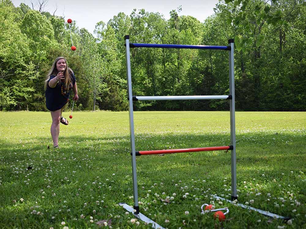 A woman playing ladder ball at QUILLY'S MAGNOLIA RV PARK