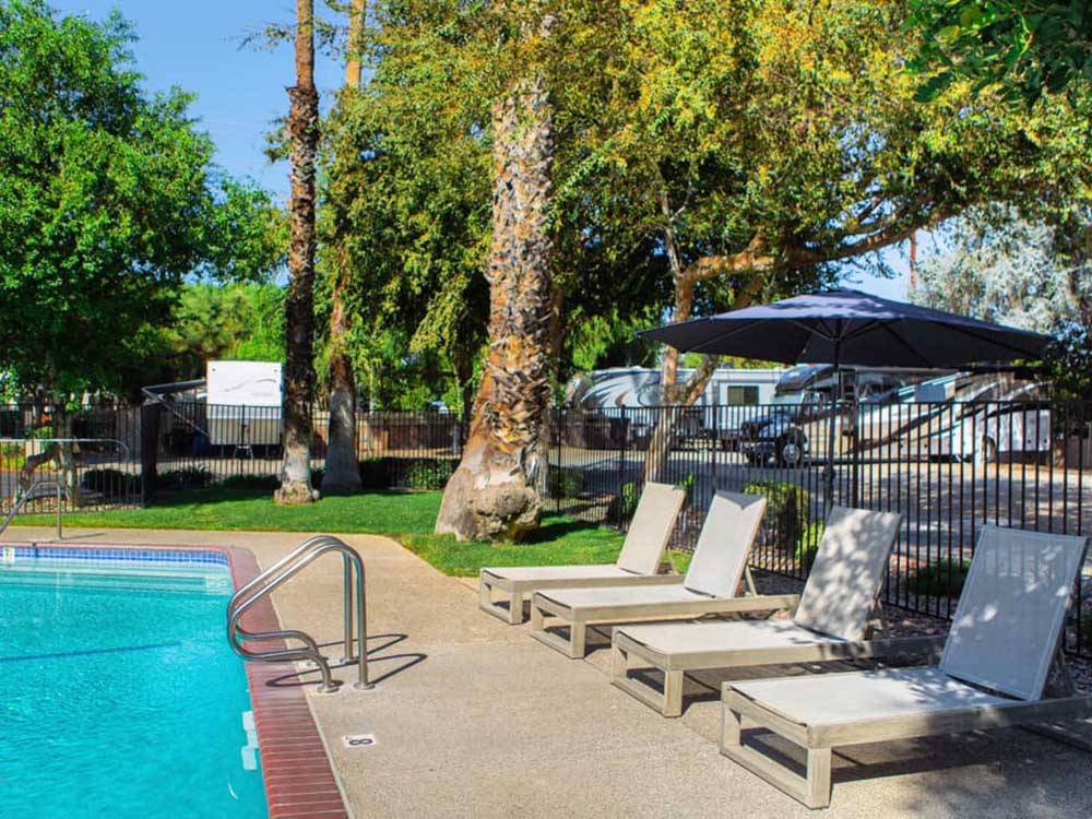Lounge chairs situated pool side at WALNUT RV PARK