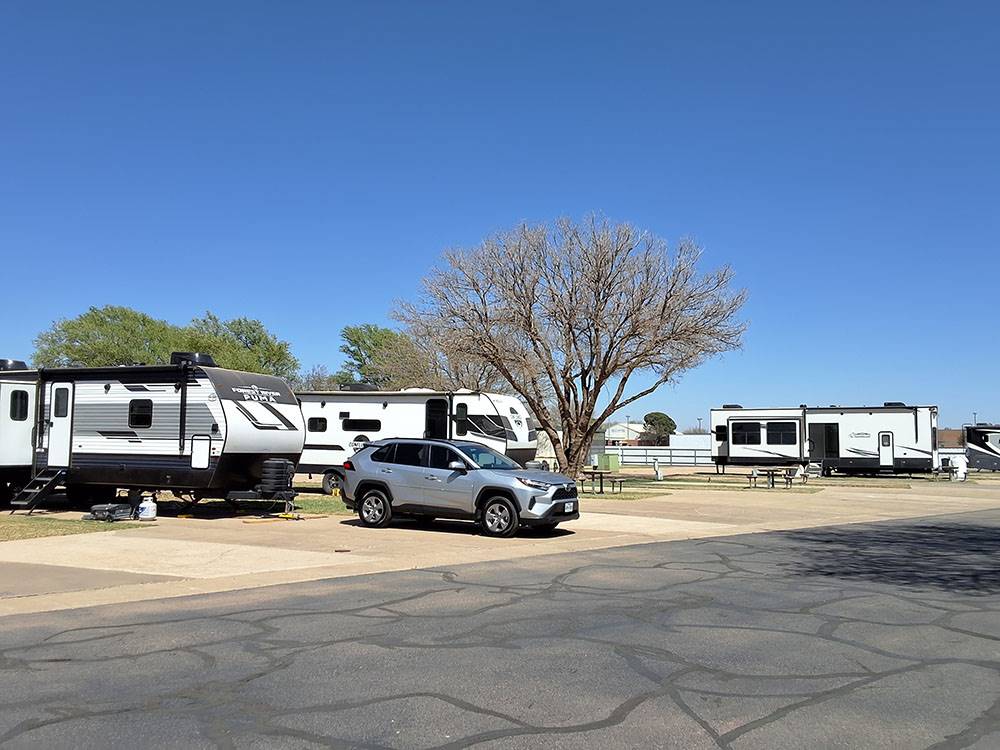 A silver SUV parked near RVs