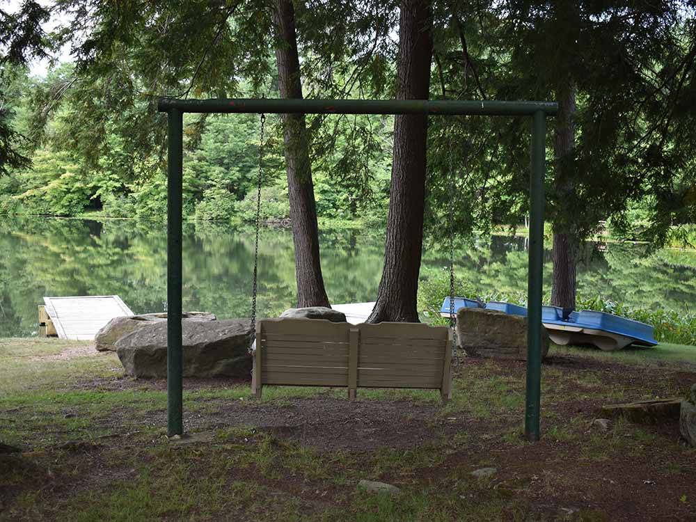 A swinging bench overlooking the water at WOODLAND CAMPGROUND