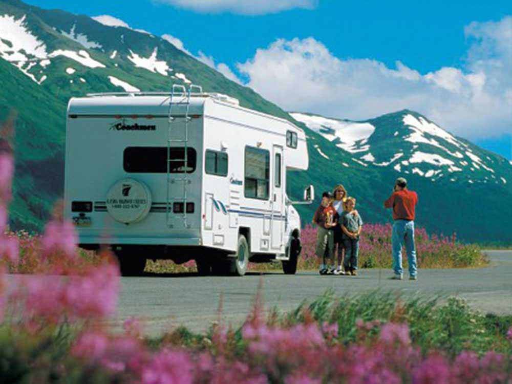 A man taking a photo of a family at ANCHORAGE SHIP CREEK RV PARK