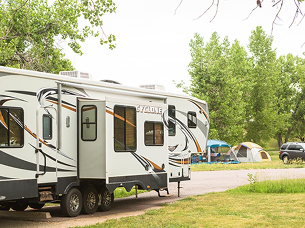 RV parked and tents in background at ON THE RIVER GOLF & RV RESORT