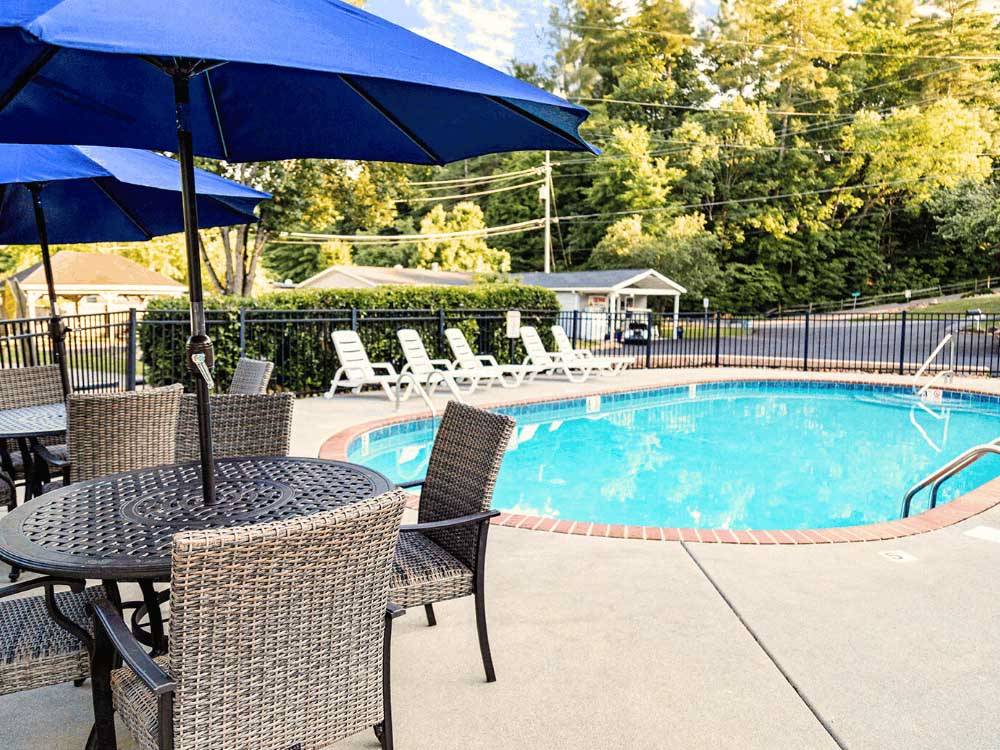 Outdoor furniture surrounding the pool at CREEKSIDE RV PARK