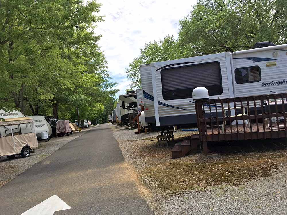 A row of RVs among some trees at OUTBACK RV RESORT
