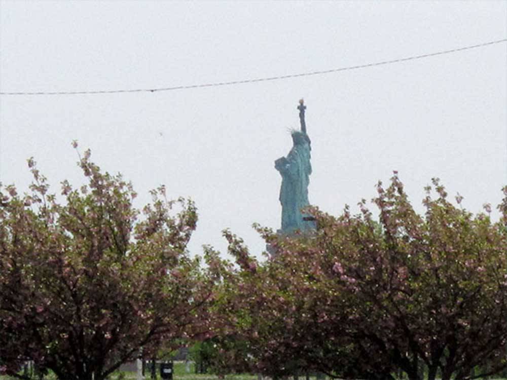 Statue of Liberty viewed over trees at LIBERTY HARBOR MARINA & RV PARK