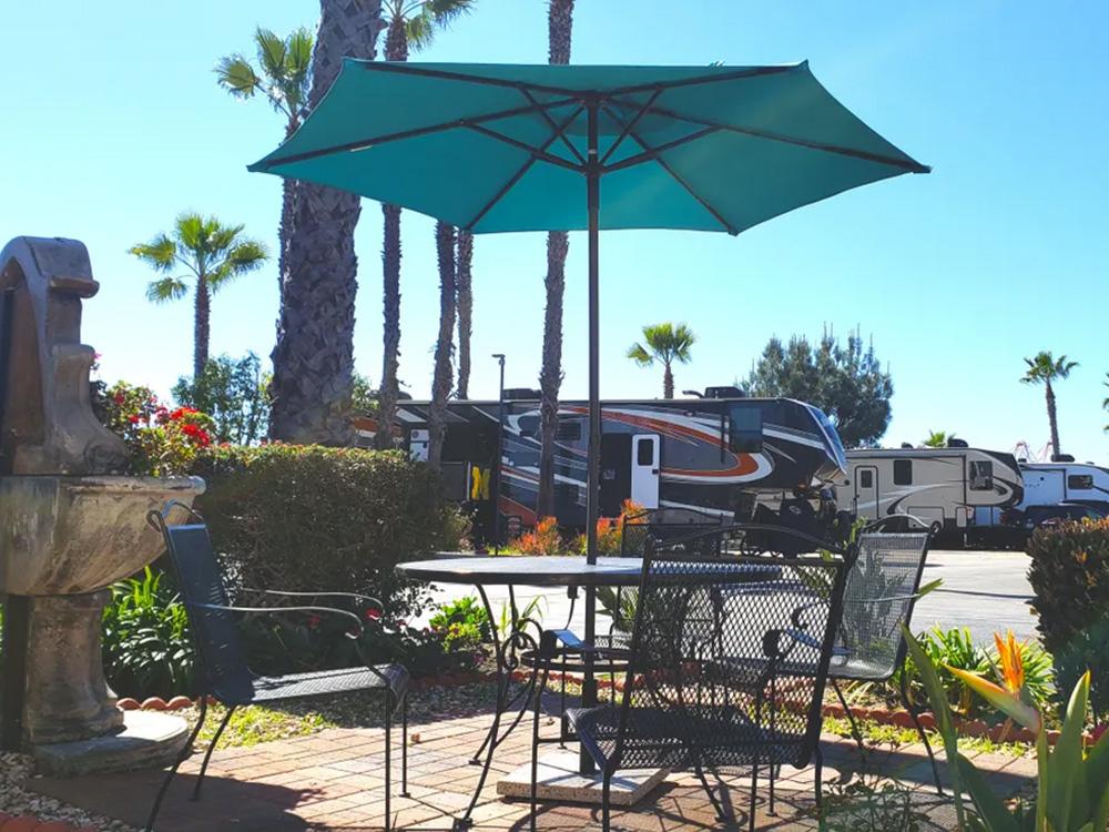 Outdoor table with umbrella near parked RVs at GOLDEN SHORE RV RESORT