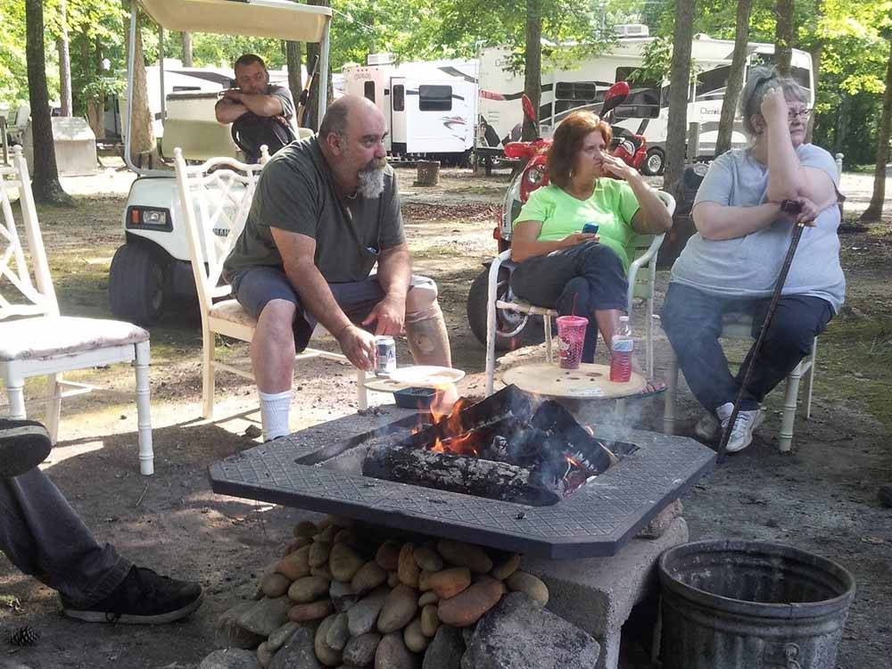 A group of people sitting around a fire pit at CAMPTOWN CAMPGROUND