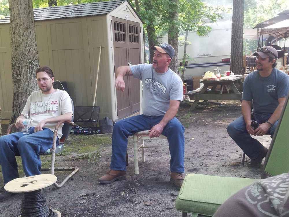 Three guys sitting in a campsite at CAMPTOWN CAMPGROUND