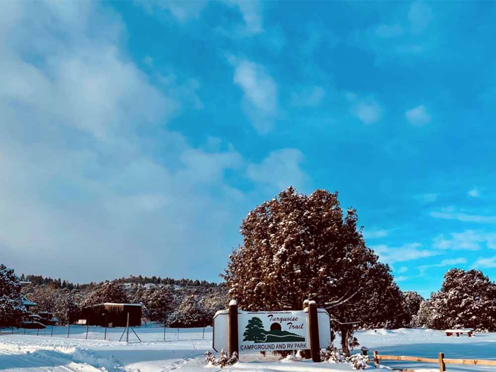Sign for Turquoise Trail amid a snow-covered landscape at TURQUOISE TRAIL CAMPGROUND & RV PARK