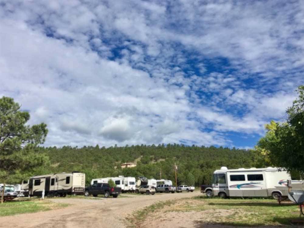 RVs in sites with hill rising in the background at TURQUOISE TRAIL CAMPGROUND & RV PARK