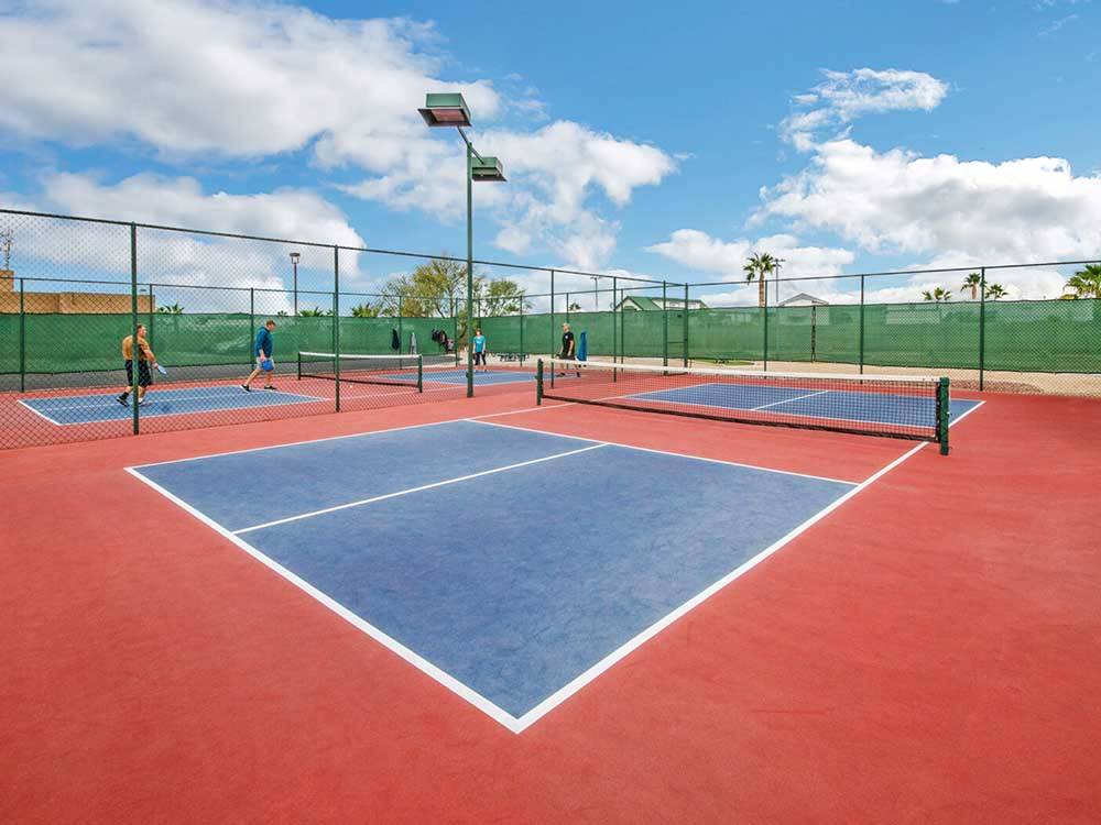 Guest playing pickleball on one court and one empty court at LAS QUINTAS RV RESORT
