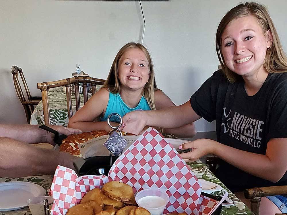 Two girls eating pizza at OSPREY POINT RV RESORT