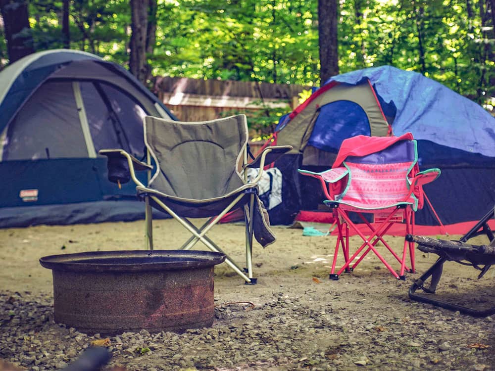 Two tents and seating by a fire ring