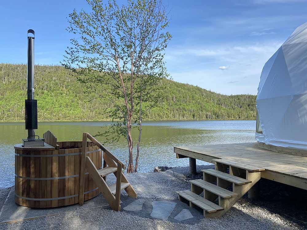 A wood fired hot tub next to the glamping dome rental at GROS MORNE/NORRIS POINT KOA