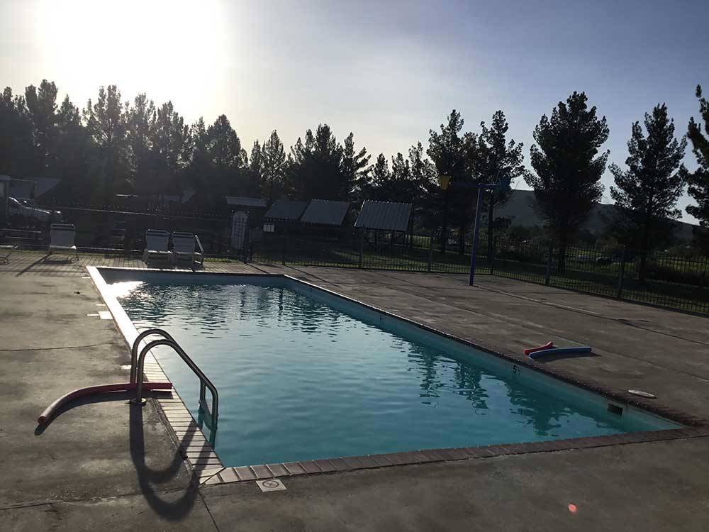 Swimming pool at campground with setting sun reflecting on its surface at LOST ALASKAN RV PARK