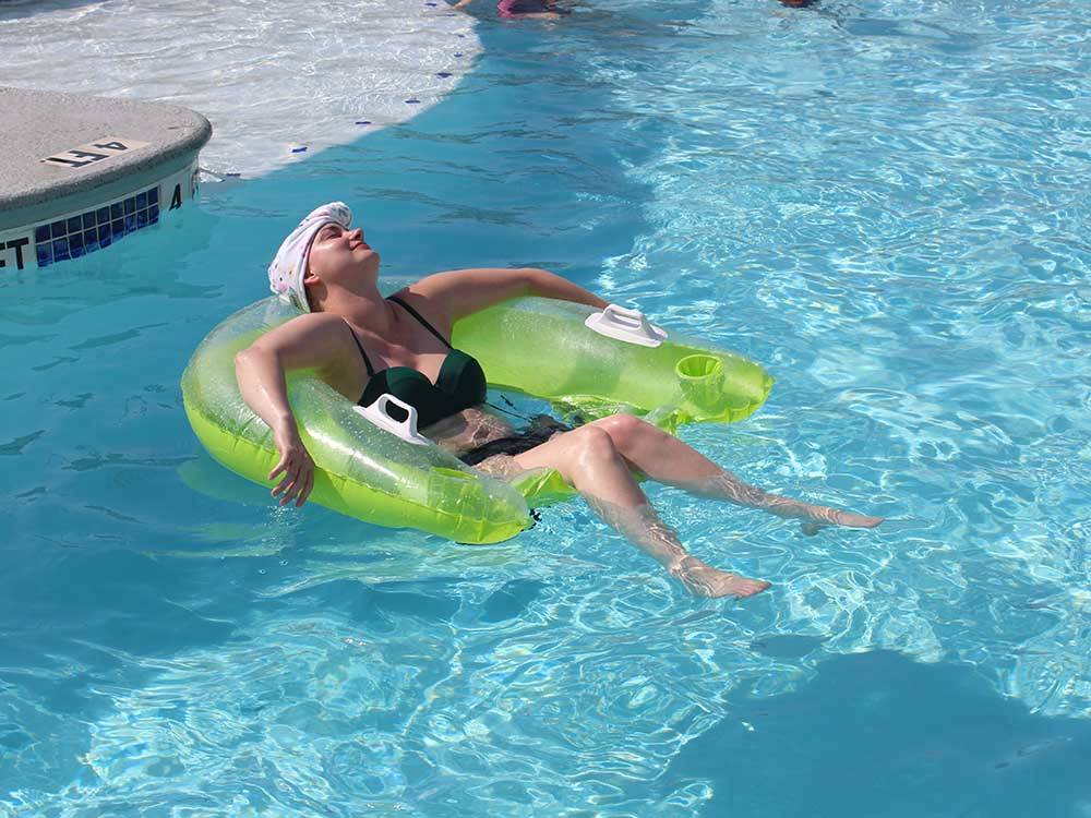 A young girl relaxing in an inflatable tube in the swimming pool at PIONEER BEACH RESORT