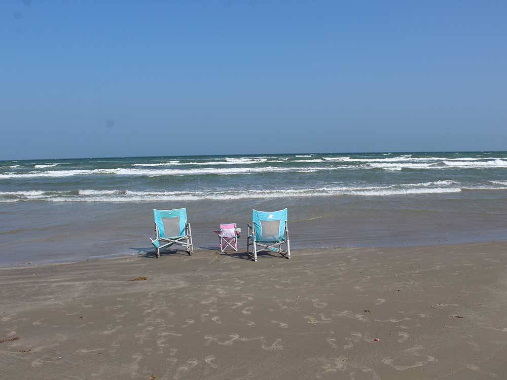 Three folding chairs on the sand at the beach at PIONEER BEACH RESORT