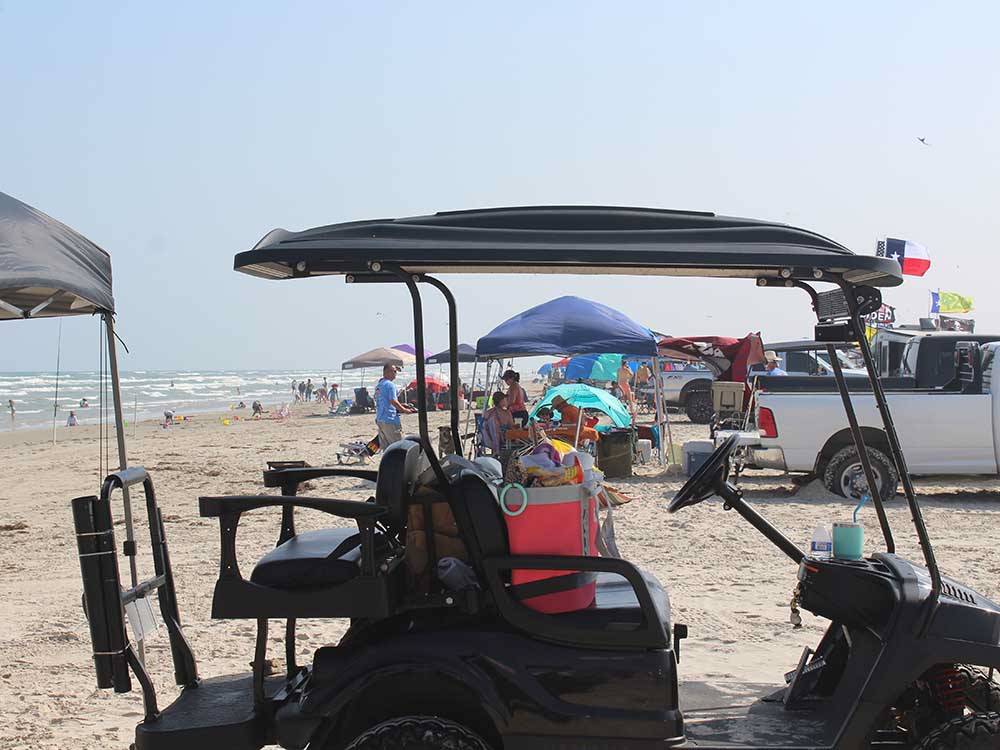 A golf cart and people at the beach at PIONEER BEACH RESORT