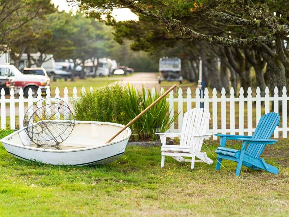 Two chairs and a boat on the grass at AMERICAN SUNSET RV & TENT RESORT