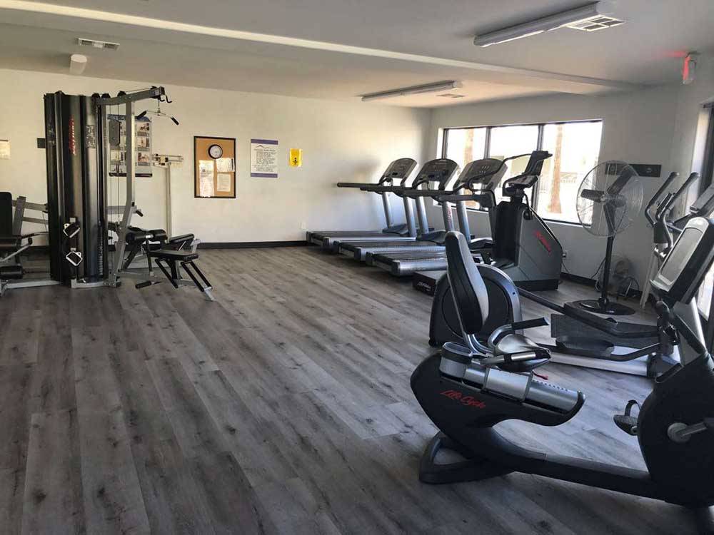 A fitness gym with wood floor, treadmills and exercise bikes at SUNRISE RV RESORT