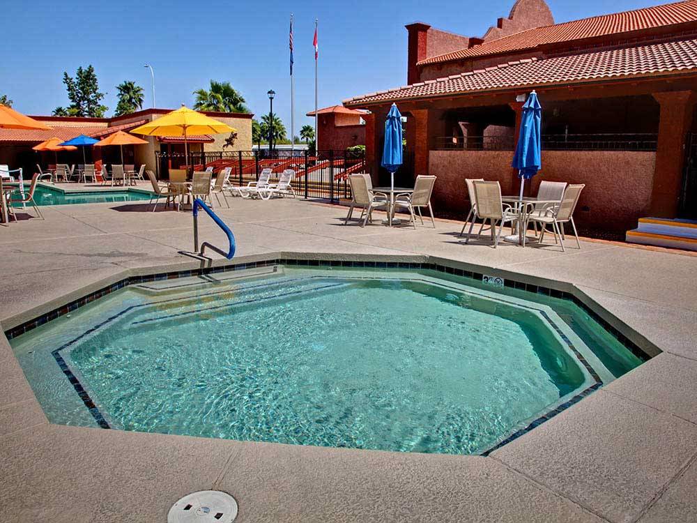 A polygon-shaped hot tub with aqua-blue water in a resort setting at SUNRISE RV RESORT
