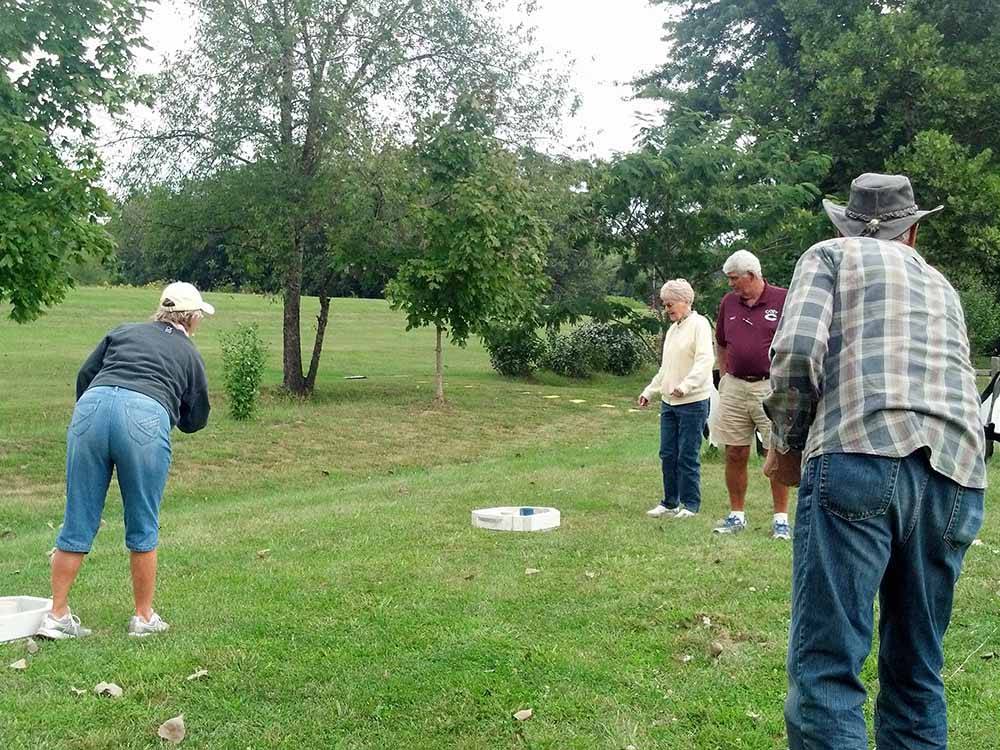 A group of people playing a lawn game at COZY C RV CAMPGROUND