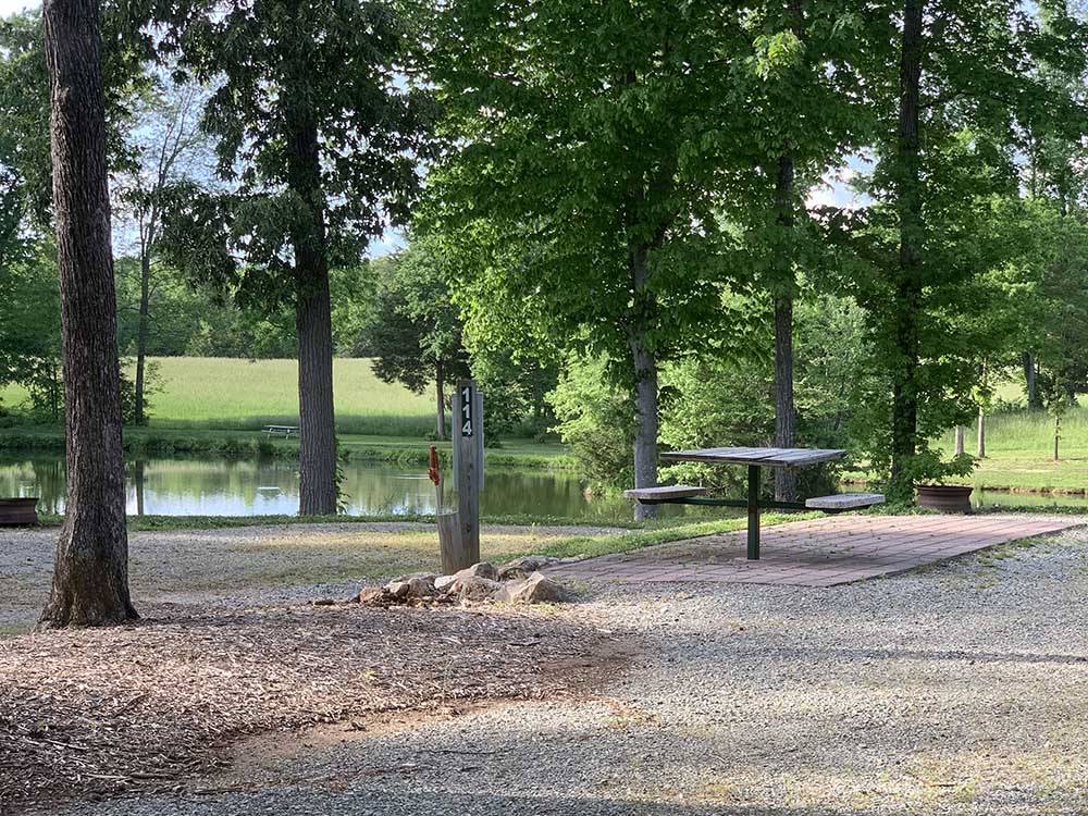 A picnic table in an RV site next to the water at COZY ACRES CAMPGROUND/RV PARK