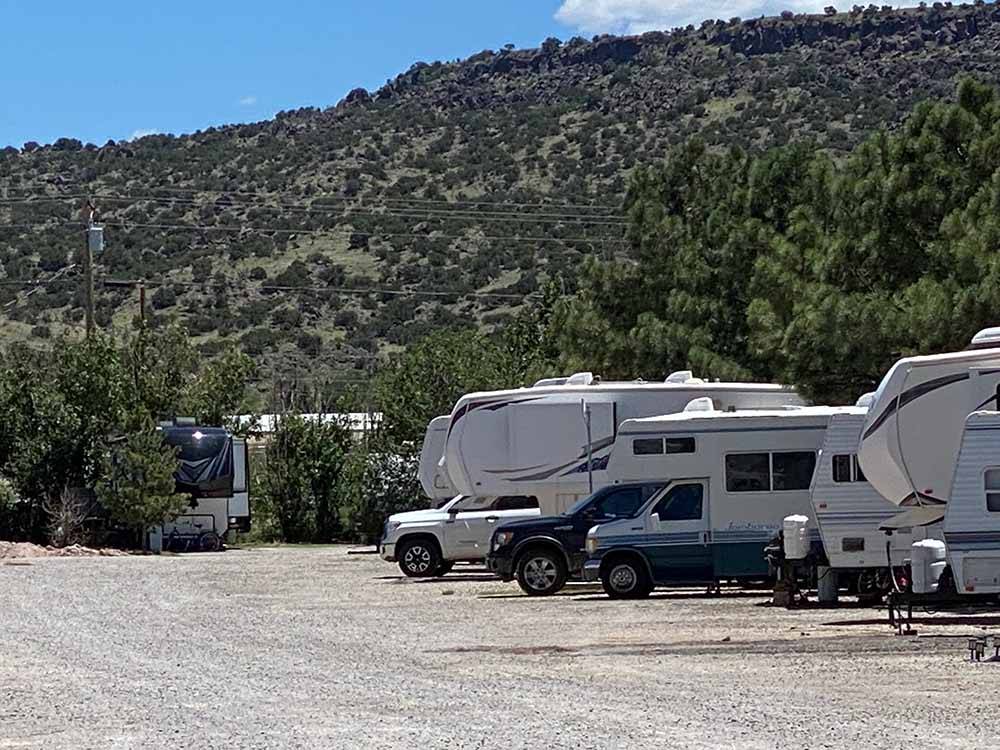RVs parked on site with large hill in distance at BAR S RV PARK