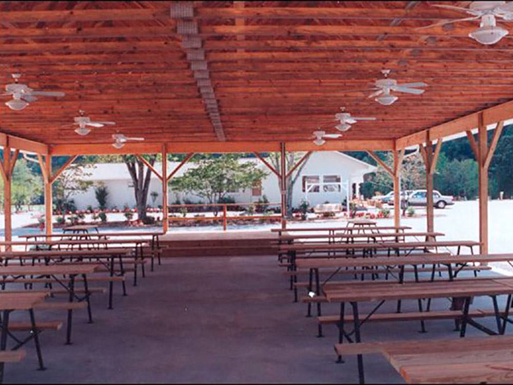Covered outdoor patio area with many community tables at KING'S HOLLY HAVEN RV PARK